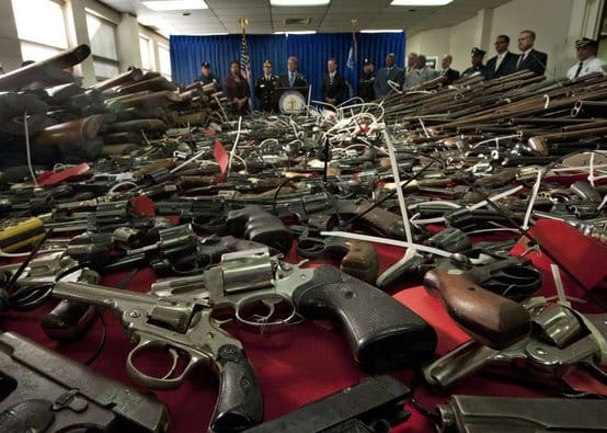NJ AG BS in front of a pile o' busted ass guns (courtesy philly.com)