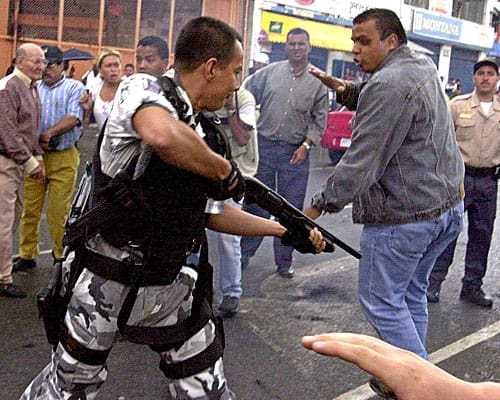Venezuelan cop and protestor (courtesy latimes.com)