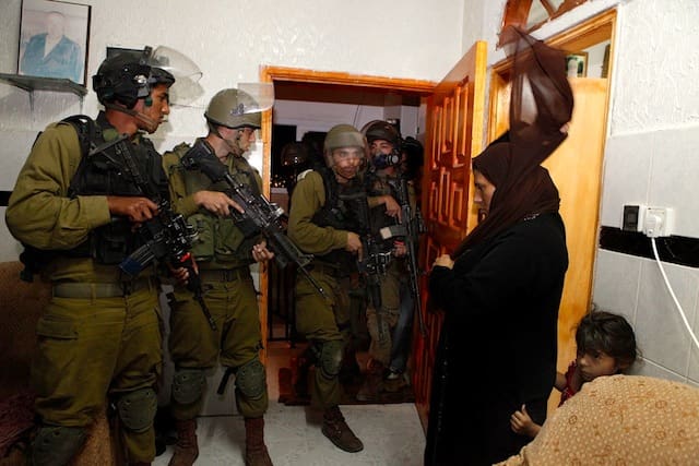 Israeli soldiers arrest Palestinian child in the West Bank (courtesy nytimes.com)
