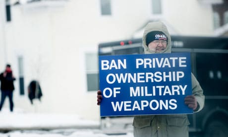 A man holds up a gun control sign as President Obama's motorcade passes in Minneapolis, Minnesota