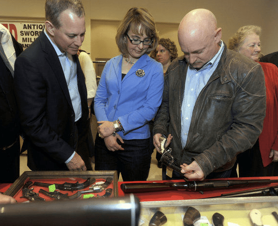 "New York Attorney General Eric Schneiderman, left, former Arizona congresswoman Gabrielle Giffords, center, and her husband Mark Kelly tour the New EastCoast Arms Collectors Associates arms fair in Saratoga Springs, N.Y. on Sunday, Oct. 13, 2013. Kelly looks at an antique revolver." (AP Photo/Tim Roske, Pool)