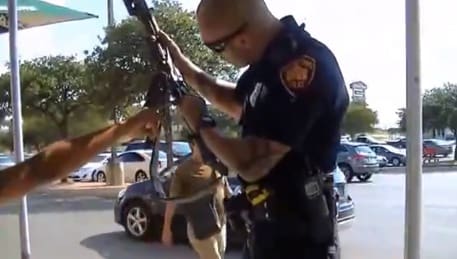 Texas police officer inspects open carry weapon (courtesy theblaze.com)