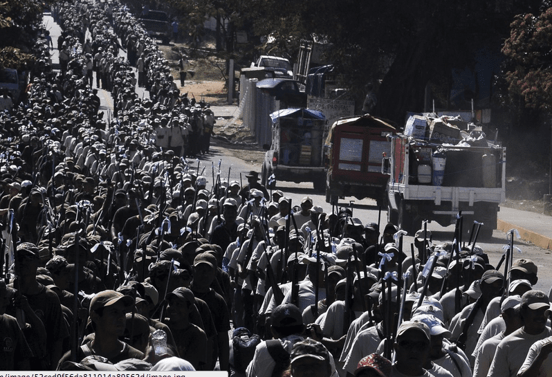 "In neighbouring Guerrero, members of the Public Safety System (the name of the vigilante group) marched to commemorate the first anniversary of their founding." (courtesy businessinsider.com.au)