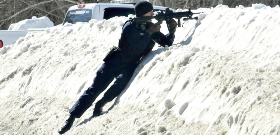 State Trooper covers ME gun tat from behind a snow bank (courtesy pressherald.com)