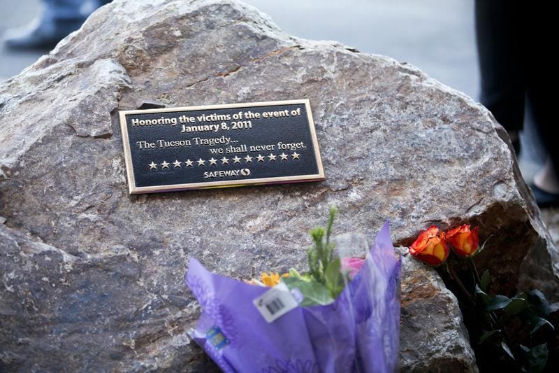 A plaque and flowers for victims of the January 8, 2011 Tucson shooting, are seen during a news conference in Tucson