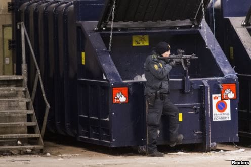 Danish policeman near dumpster (courtesy voanews.com)