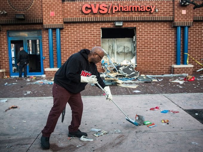 Jerald Miller cleaning-up the front of CVS after rioters burned the store (courtesy usatoday.com)