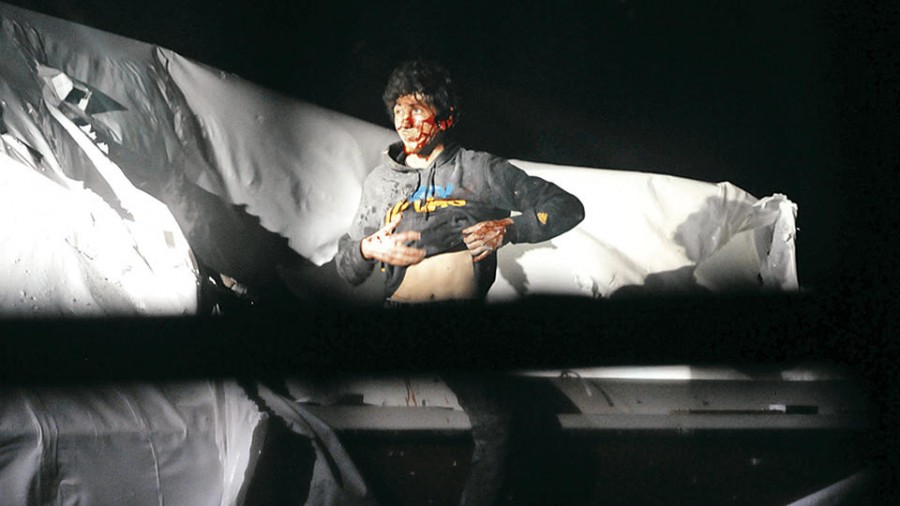 In this Friday, April 19, 2013 photo provided by the Massachusetts State Police, Boston Marathon bombing suspect Dzhokhar Tsarnaev lifts his shirt while standing in a boat at the time of his capture by law enforcement authorities in Watertown, Mass. Photos of the Boston Marathon bombing suspect's surrender have been posted on the Boston Magazine website. The additional images, made public Tuesday, were among those released to the magazine last month by a state police photographer. (AP Photo/Massachusetts State Police, Sean Murphy)