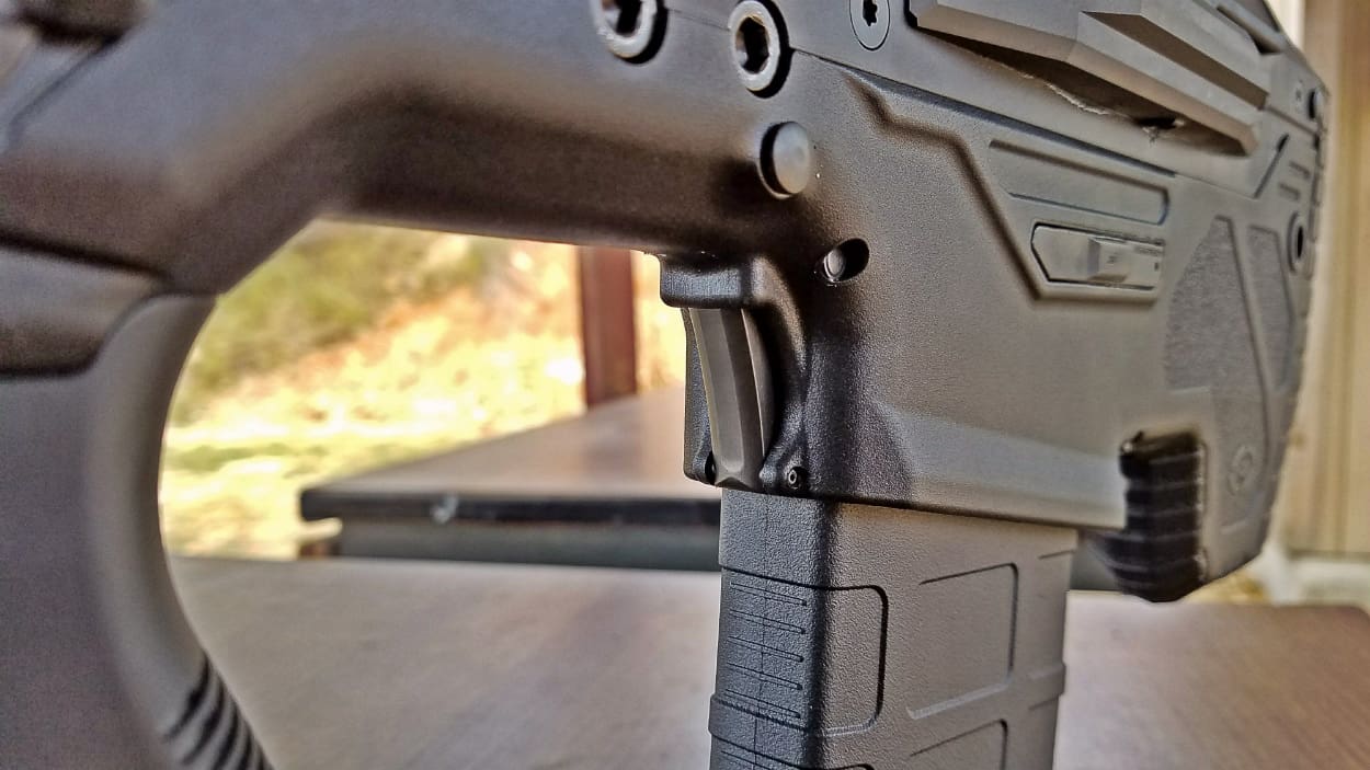 A third magazine-release button is located on the front of the mag well. 