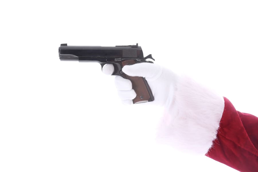 Santa Claus arm wearing white gloves points a Hand Gun. 45 calib