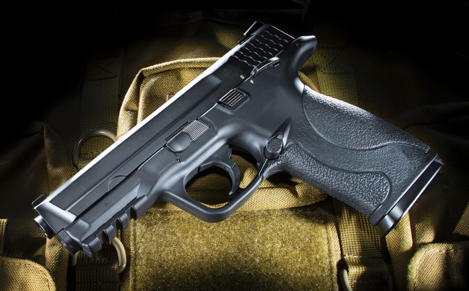 Black Semi Automatic Handgun With Polymer Frame On A Beige Bag