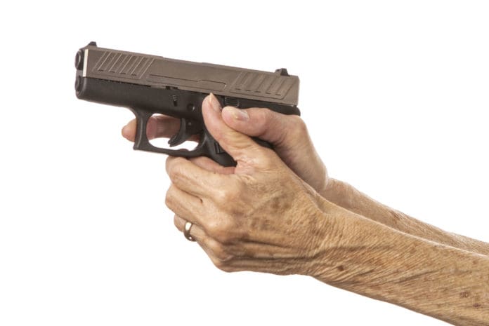 old woman senior gun hands grip