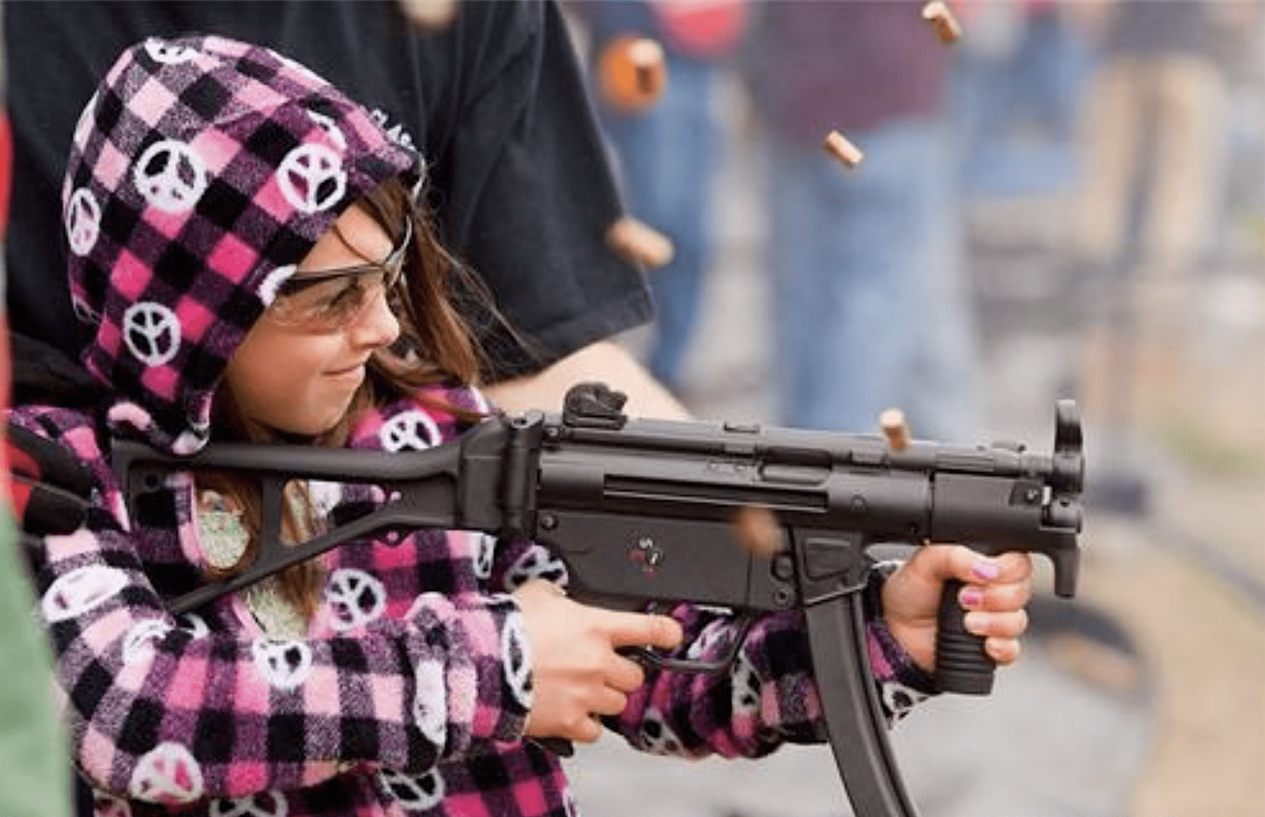 girl shooting machine gun peace sign